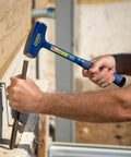 Man using Big Blue 4 Pound Drilling Hammer With Long Handle Built Like a Tank Forged Steel Construction Shock Reduction Grip Made in USA for chiseling