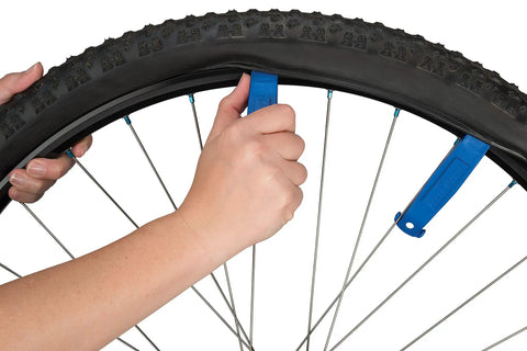 Using Three Tire Levers Set With TL-1.2 Narrow Tip for quick tubeless tire removal on bike wheel, TL-6.2 in spoke hook.