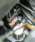 Close-up of Premium Telescoping Magnetic Pickup Tool reaching into engine bay with flexible grabber for auto repair projects.