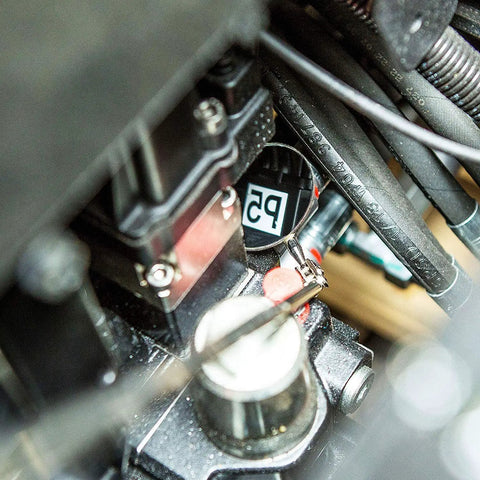 Close-up of Premium Telescoping Magnetic Pickup Tool reaching into engine bay with flexible grabber for auto repair projects.