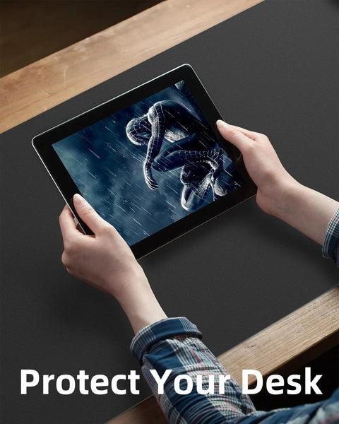 Person holding tablet on Extra Large PU Leather Desk Pad For Home Office Non Slip Waterproof Blotter Mat With Mouse Pad And Keyboard Desk Mat For Dual Screens And Two Computers 48 By 17 Inches Black