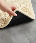 Heavy Duty Rug Gripper Pads With Adhesive Strips For Non Slip Carpet Corners shown applied under a rug on tile floor