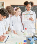 Students using Durable PVC Periodic Table Chart Laminated Poster in chemistry class with equation sheet and reference.