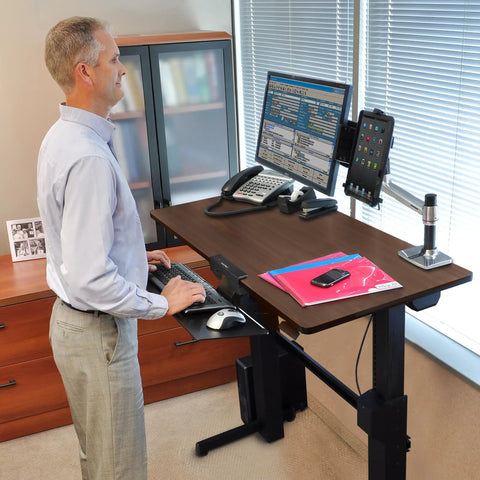 Height Adjustable Standing Desk Supporting Dual Screens And Tablets Heavy Duty Sit Stand Workstation with walnut surface in office setting.