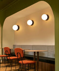 Matte Black Modern Globe Wall Sconce 1 Light With Opal Glass Shade in hallway seating area