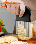 Waffle fry cutter with black handle and stainless steel blades cutting a potato into waffle fries