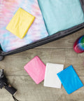 Kids Rain Ponchos Pack Of 20 Disposable With Hood, 4 assorted colors, arranged near suitcase and shoes, 42 by 60 inches