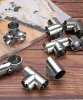 Six Piece 1 Inch Tee Pipe Connectors Set for DIY Shelves and Garden Supports, stainless steel, on wooden surface, silvery finish.