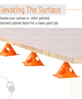 Painters Pyramid Stands 20 Pack for Canvas Elevation and Pouring, pro-grade ABS plastic stands elevating a wooden board