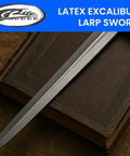28 Inch Latex Excalibur LARP Sword with black and silver finish resting on a leather-bound book, medieval cosplay prop