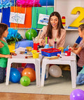 Children painting on a Quick Drop 8 Oz Canvas Safety Drop Cloth With Slip Resistant Dots, surrounded by colorful balloons and art supplies.