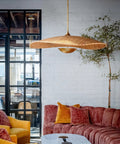 Totally Main Character Energy One Light Pendant Ceiling Light Fifty Two Inches Wide Vintage Gold Leaf Metal Dome Shade Hanging Lamp above a cozy living room.
