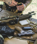 M-Pact 0.5mm High-Dexterity Covert Tactical Work Gloves With Touchscreen Capability on table with firearms and ammunition