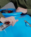 Person uses Outdoor Gear UV Protectant and Conditioner Spray for Plastic, Vinyl, and Neoprene That Shields Against Sun Damage on kayak