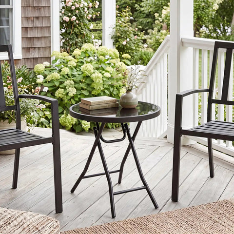 Compact Outdoor Folding Side Table With Tempered Glass Top And Heavy Duty Steel Frame for patio with books and vase.