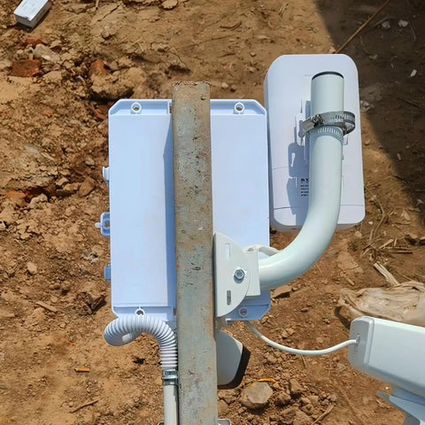 Universal Wireless Bridge Bracket Mount 2 Pack Pole And Wall Mount For Outdoor Antenna installed on a metal pole with cables.