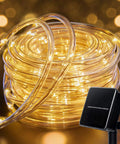 Coiled Solar Rope Lights Outdoor 72 Feet 200 LED Waterproof Copper Wire Fairy Lights next to solar panel