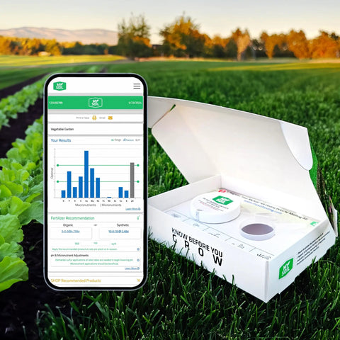 Open soil test kit box on grass with smartphone showing results screen. Soil Test Kit For Lawn And Garden Health To Get Your Lawn Game Right With Complete And Accurate Nutrient And PH Analysis And Tailored Recommendations For Your Soil And Plant Needs.