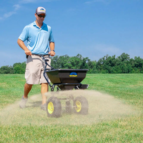 Man using Spyker All Season Spreader Kit Ergo Pro 50 Pound Broadcast Spreader With 25 Pound Bag Spreader on lawn