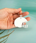 Hand holding helmet-shaped keychain from Helmet Shape Sublimation Keychain Blanks Kit, 20 Pieces With Rings And Clips For DIY Ornaments