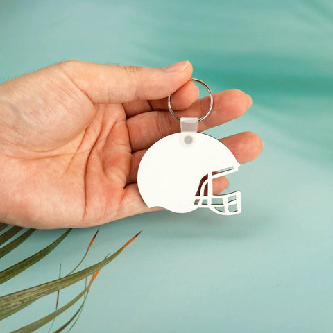 Hand holding helmet-shaped keychain from Helmet Shape Sublimation Keychain Blanks Kit, 20 Pieces With Rings And Clips For DIY Ornaments