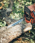 Person using a chainsaw to cut a log in a forest setting, showcasing power and efficiency for timber work.