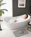 Woman relaxing in a 59 Inch Acrylic Freestanding Bathtub Glossy White Deep Ergonomic Soaking Tub with bubbles.