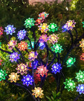 Solar Garden Lights Outdoor Decorative Six Pack Multicolor LED Flower Stakes vibrant display in garden at night