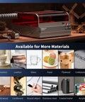 Falcon2 Pro 22W Enclosed Laser Engraver With Air Assist And HD Camera Positioning on a workshop table with various engravable materials