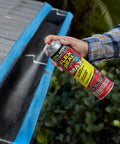 Person spraying gutter with clear rubber sealant, illustrating Two Pack 17 Oz Clear Rubber Sealant Spray That Stops Leaks Instantly