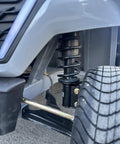 Heavy Duty Four Seater Electric Golf Cart With Premium Luxury Seats And Badass Off Road Tires Straight Fire Backyard Cruiser close-up of shock absorber and tire.