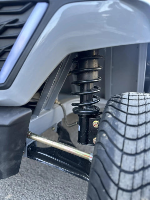 Heavy Duty Four Seater Electric Golf Cart With Premium Luxury Seats And Badass Off Road Tires Straight Fire Backyard Cruiser close-up of shock absorber and tire.