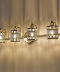 Over Mirror Four Bulb Bathroom Vanity Light With Cylinder Crystal Shade Modern Wall Sconce illuminating a room