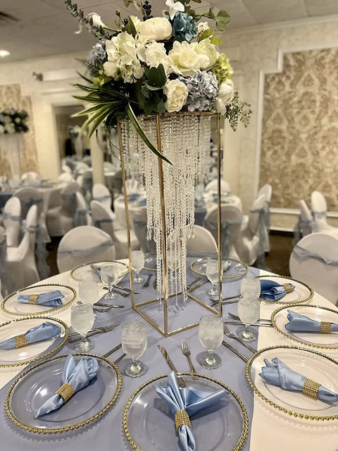 Elegant table setup with centerpiece of cascading crystal strands and floral arrangement at a wedding reception.