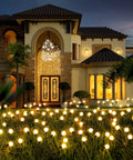 Four Pack Solar Garden Path Lights With 8 LED Firefly Glow Waterproof Outdoor Yard Decor illuminating a lush garden at dusk