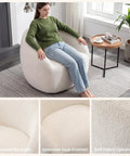 Woman sitting on White Boucle Swivel Chair With 360 Degree Base, Oversized Round Barrel Accent Chair For Living Room