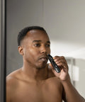 Man using Weed Whacker 2.0 Nose and Ear Hair Trimmer with 7000 RPM Motor for clean trim, showcasing easy clean, wet dry use.
