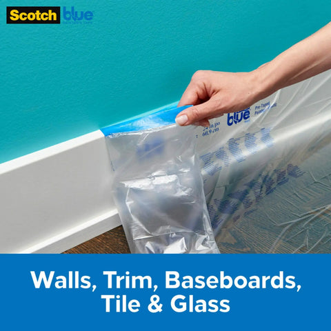 Hand applying Paint Tape With Plastic Duo That Clings For Easy Positioning And No Residue Finish 48 Inch Wide Masking Film on baseboard