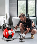 Man using Heavy Duty Electric Drain Auger With Sharp Rotary Blades And Foot Switch For Smashing Backed Up Lines In One To Four Inch Pipes Using Tangle Free Steel Core Snake in a bathroom setting.