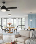 Modern kitchen and dining area with beige sofa, light fixtures, black chairs, and blue cabinets