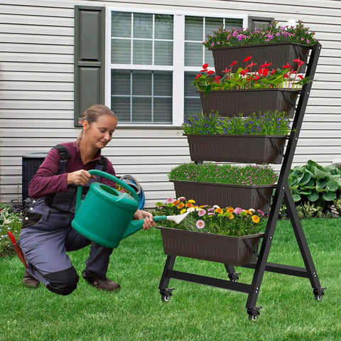 Person watering plants in Five Tier Vertical Garden Planter With Water Drainage, Elevated Raised Garden Bed For Vegetables, Flowers, And Herbs.