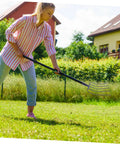 Person using Beast Of A Grass Fork For Manure Handling And Garden Cleanup in rural lawn setting