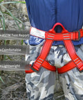 Adjustable Thickness Climbing Harness With Wide Half Body Design For Rock Climbing Rappelling Fire Rescue And Tree Work CE EN3531 Certified Heavy Duty Workhorse Polyester Gear With Max Load 230kg And Breaking Strength 22kN In Red shown around the waist and legs of a person outdoors.