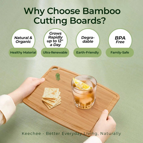 Person holding dishwasher safe carbonized bamboo cutting board with juice groove, cheese, and drink on top