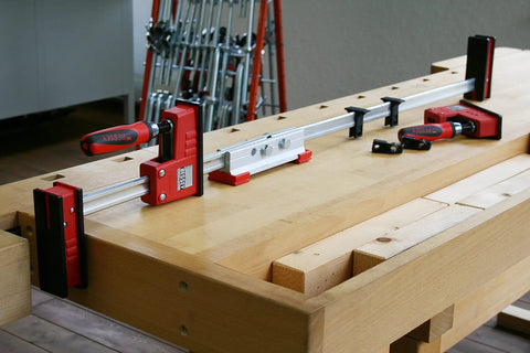 K Body REVO Extender for Dual Clamp Sets on workbench, aluminum build, joining KRE KR K KREV KRV clamps for extended reach in woodworking.
