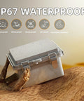 All Weather Outdoor Electrical Box IP67 6x6 Plastic Project Enclosure on sand with water droplets and stainless steel hinged lid