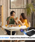 Couple eating pizza in living room with 1080p WiFi Security Cam With Night Vision Indoor Outdoor Nanny Cam For Home Or Office Local And Cloud Storage Quick Setup Sleek Minimalist Build That Blends In Anywhere visible in corner
