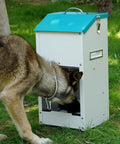 Top Notch Galvanized Gravity Auto Dog Feeder With 15 Lb Size and Rust Resistant Stainless Steel Shovel being used by a dog outdoors.
