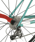 Grunge Brush Bike Chain And Gear Cleaner With Dual Sided Bristles cleaning bike gears and derailleur on teal frame