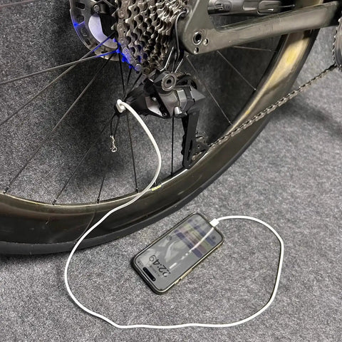 Type C Battery With Lanyard For 12 Speed E Bike Replacement Adapter connected for on the go charging, phone on grey carpet